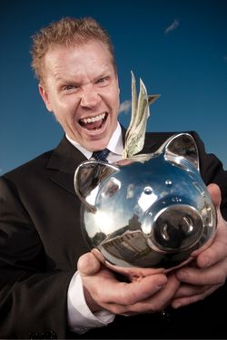 Greedy man holding a silver piggy bank