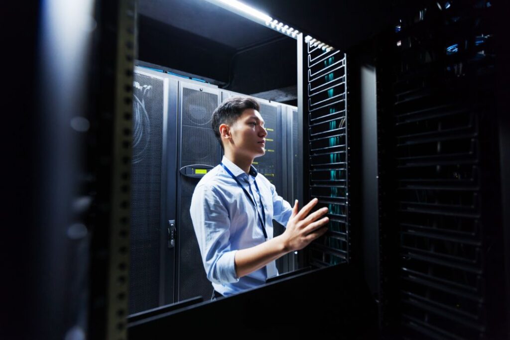 Young IT engineer exploring data center servers